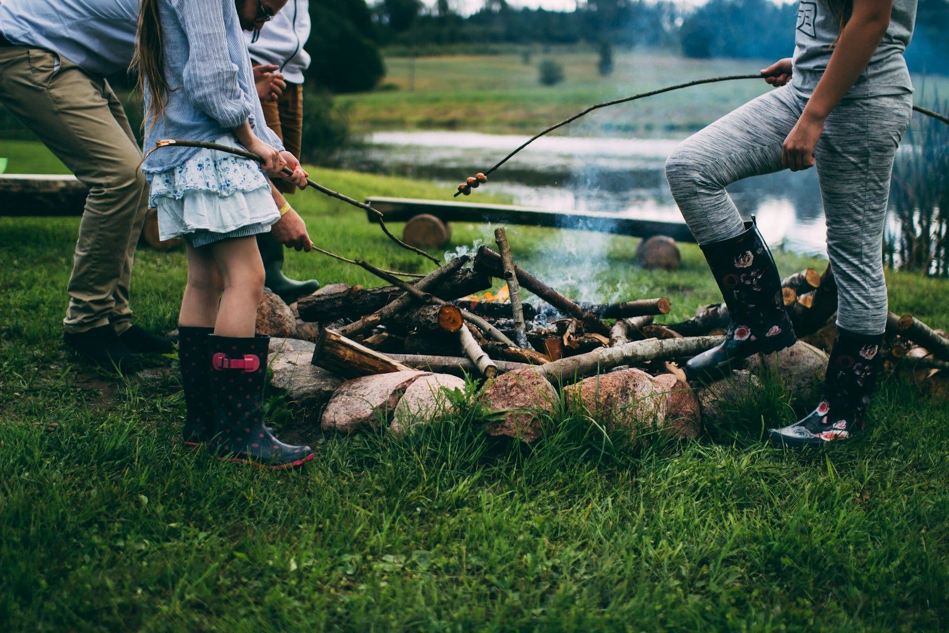 Familie mit Stockbrot am Lagerfeuer